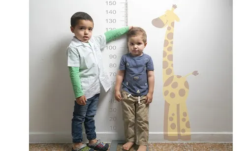 Niño midiendo a un niño más pequeño